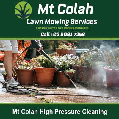 Worker pressure washing concrete surface in Mt Colah